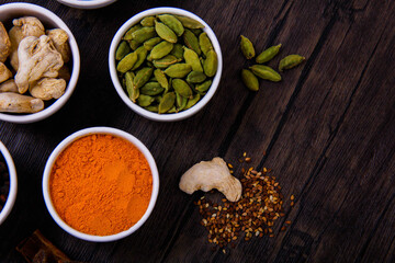 Different types of spices in small dishes with different colors together from the top view.
