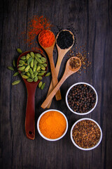 Different types of spices in small dishes with different colors together from the top view.
