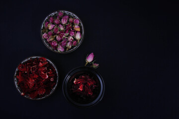 Fototapeta premium Different types of spices and decorative flowers and edible and fragrant in small dishes with different colors together from the top view.