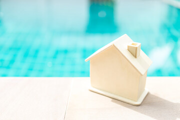 Wooden house over blurred swimming pool background, summer outdoor day light, new house, property business