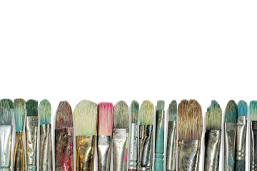 old oil paint brushes isolated at the bottom of a white background