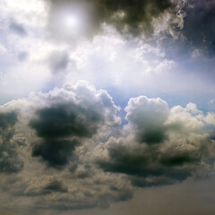 Overcast sky and the sun behind cumulus clouds.