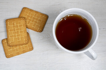 Tea in a white cup with cookies top view.