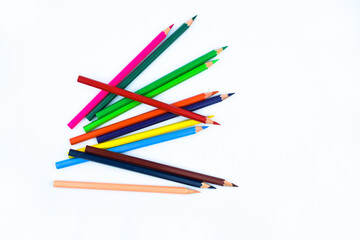 A stack of different colored wood pencil crayons placed on a white paper background