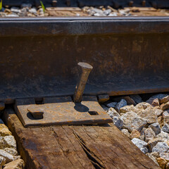Closeup detail of a loose railroad spike on a single line spur track