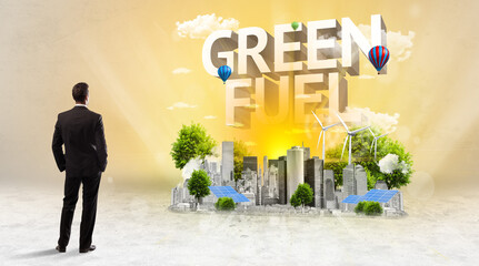 Rear view of a businessman standing in front of GREEN FUEL inscription, Environmental protection concept