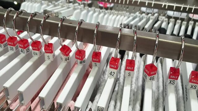 Shop. Hangers with clothes of different sizes. Sales time.