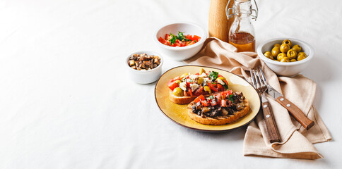 Delicious bruschettas with mushrooms, blue cheese, olives and tomatoes