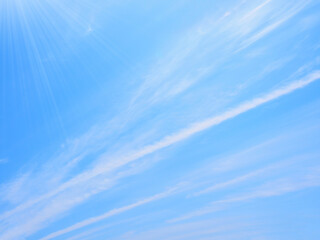 輝く陽光と筋雲のある青空