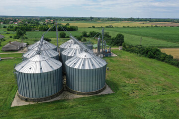 Fototapeta na wymiar Agricultural silos on the farm, close-ups from above with a drone. Farm Industrial granary, elevator dryer, building exterior, storage and drying of cereals, wheat, corn, soybeans, sunflowers.