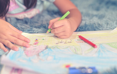 Close up child drawing and painting of her family in home for create greeting card or homework