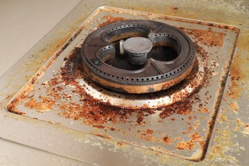 Dirty modern gas stove with cooking oil stains and burned food remnants on surface