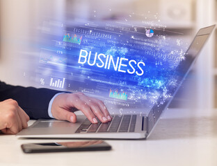 Closeup of businessman hands working on laptop with BUSINESS inscription, succesfull business concept