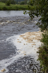 White foam pollution in a river contaminating the environment