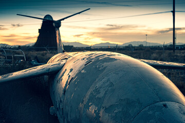 Old military airfare aircraft in a junkyard during sunset in New Mexico