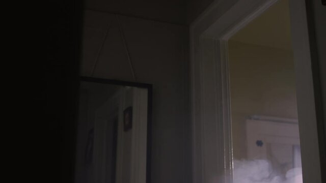 Smoke starts to rise from a bedroom doorway after a house fire starts