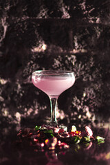 cosmopolitan pink cocktail in coupe martini glass  on brick background