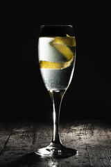 French 75 champagne cocktail with lemon zest on black background