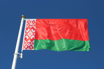 Naklejka na ściany i meble Flag of Belarus against the blue sky.