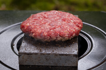 Burger meat cooking on top of hot volcanic stone