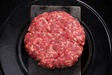 Burger meat cooking on top of hot volcanic stone