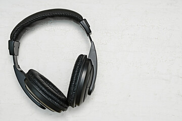 Large, black headphones lie on a colored background. Device for individual listening to music.