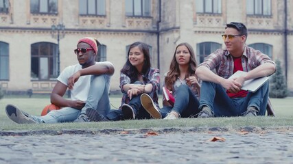 Friends gathered on the street on the weekend and re-read their journal entries from the first day they entered university. Group of young students re-reading notes from the lesson. Prores 422. 