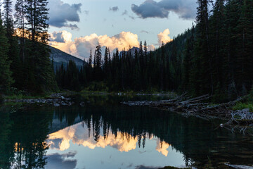 Sunset with puffy clouds with reflection on a lake wide view