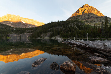 Fototapeta na wymiar sun light hitting the top of the mountains with a lake