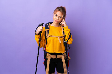 Teenager girl with backpack and trekking poles over isolated purple background thinking an idea