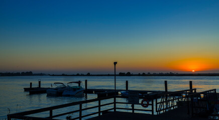 Naklejka na ściany i meble Sunrise seen from the boat dock in the delta