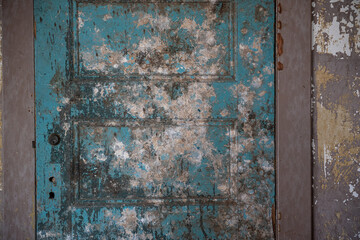 Peeling off blue paint old grungy door background or texture