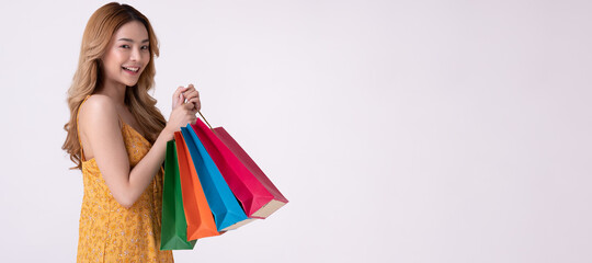 Happy asian woman holding shopping bag with mid year sale.