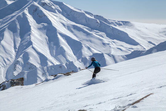 A woman skiing downhill on snow covered Himalayan Mountain in Gu