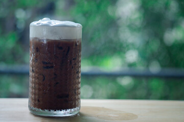 Ice coffee with milk cream in a tall glass