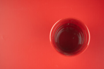 Red plastic glass on red background
