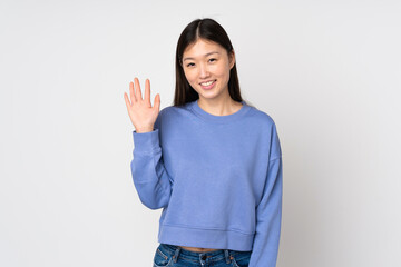 Young asian woman isolated on background saluting with hand with happy expression