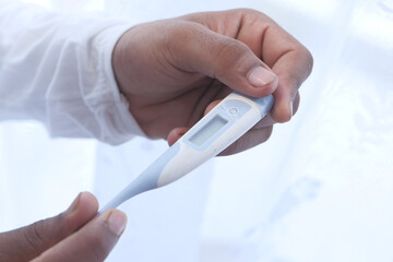 close up of man hand holding digital thermometer.