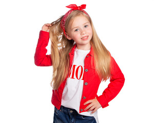 A beautiful European blonde in red smiles and touches her long hair on a white background. Portrait of a beautiful child. Happy child.
