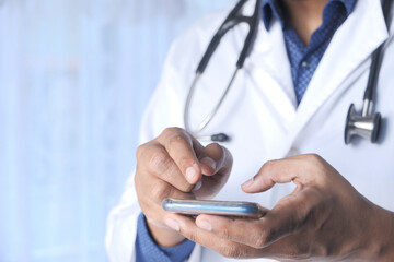 doctor in white coat using a smartphone.