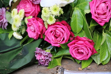 Gesteck mit pinken Rosen und Blumen nach Beerdigung auf dem Friedhof