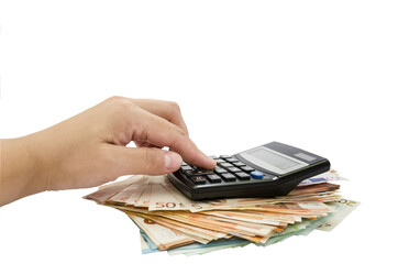 Female hand is typing on a calculator against the background of a heap of euro banknotes / isolated...