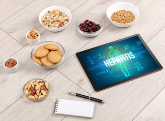 HEPATITIS concept in tablet with fruits, top view