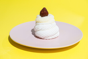 white cake on a pink plate on a yellow background