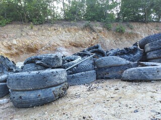 Industrial landfill for the processing of waste tires and rubber tyres. Pile of old tires and wheels for rubber recycling. Tyre dump