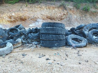 Industrial landfill for the processing of waste tires and rubber tyres. Pile of old tires and wheels for rubber recycling. Tyre dump
