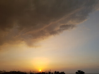 A romantic sunset over the city and the ocean in the distance.