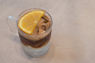 A glass of ice black coffee and orange juice