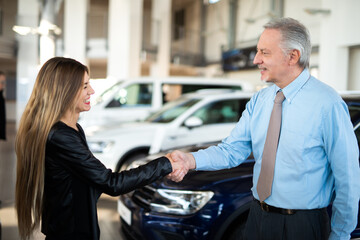 Car dealer new car, woman giving handshake to the car dealer to seal the deal