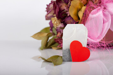 tea bag with heart tag on floral background